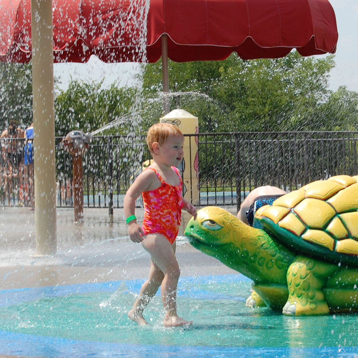 Child playing on wet playground with turtle play object