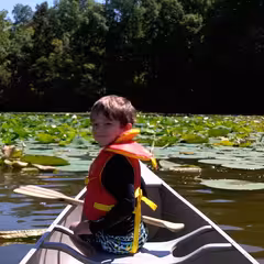 Boy in the front of a canoe on a lake