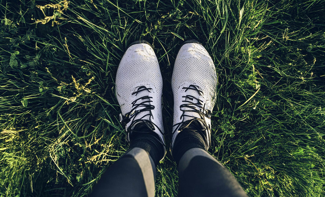 a person's feet in a grass field