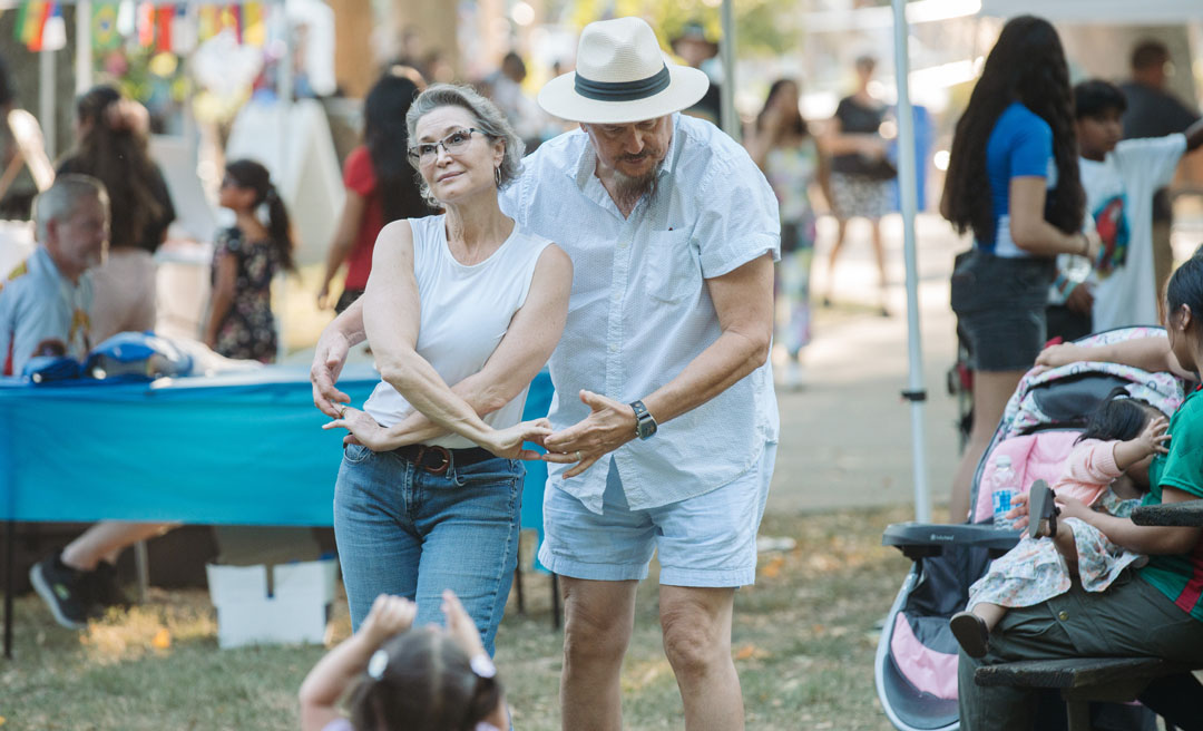 a man and woman dancing outside