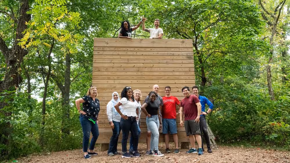 Corporate team doing a wall climbing exercise