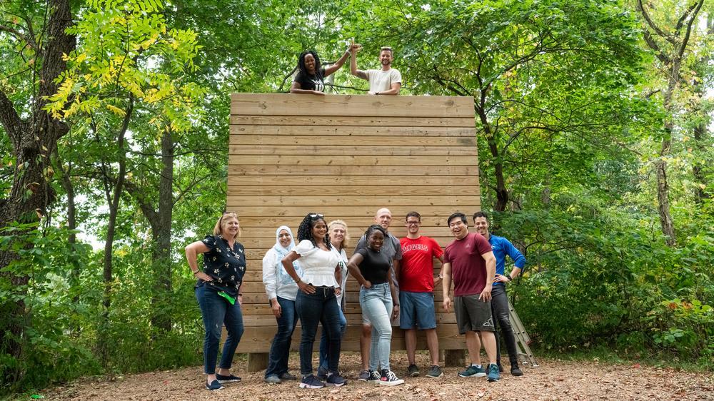 Corporate team doing a wall climbing exercise