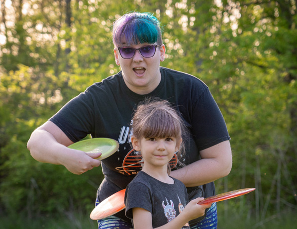 a woman and a girl holding frisbees