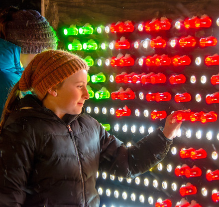 a woman touching a wall with lights