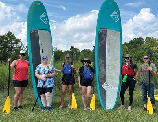 a group of people standing in a row with paddles