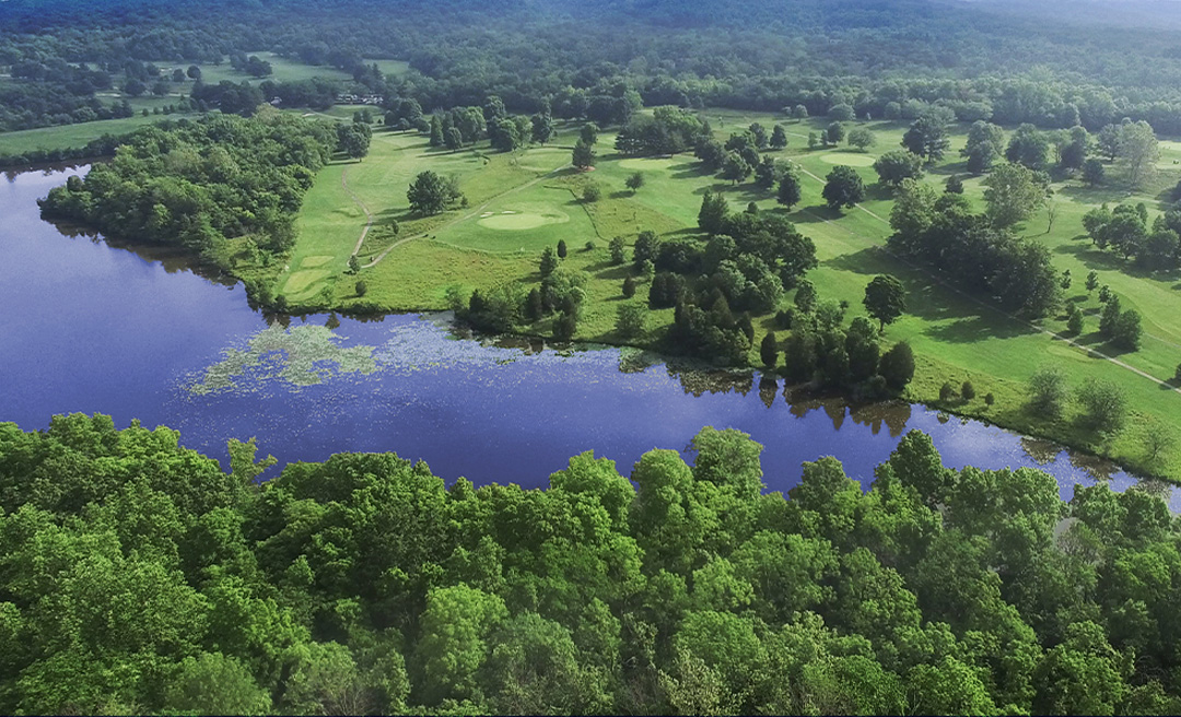 View of a golf green with a yellow tee flag at Miami Whitewater Forest Golf Course