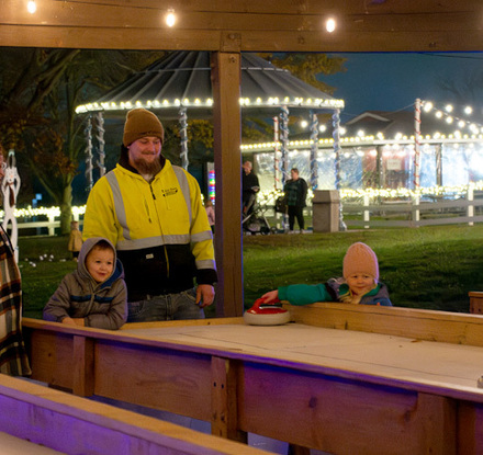 a man and two children standing in front of a wooden table