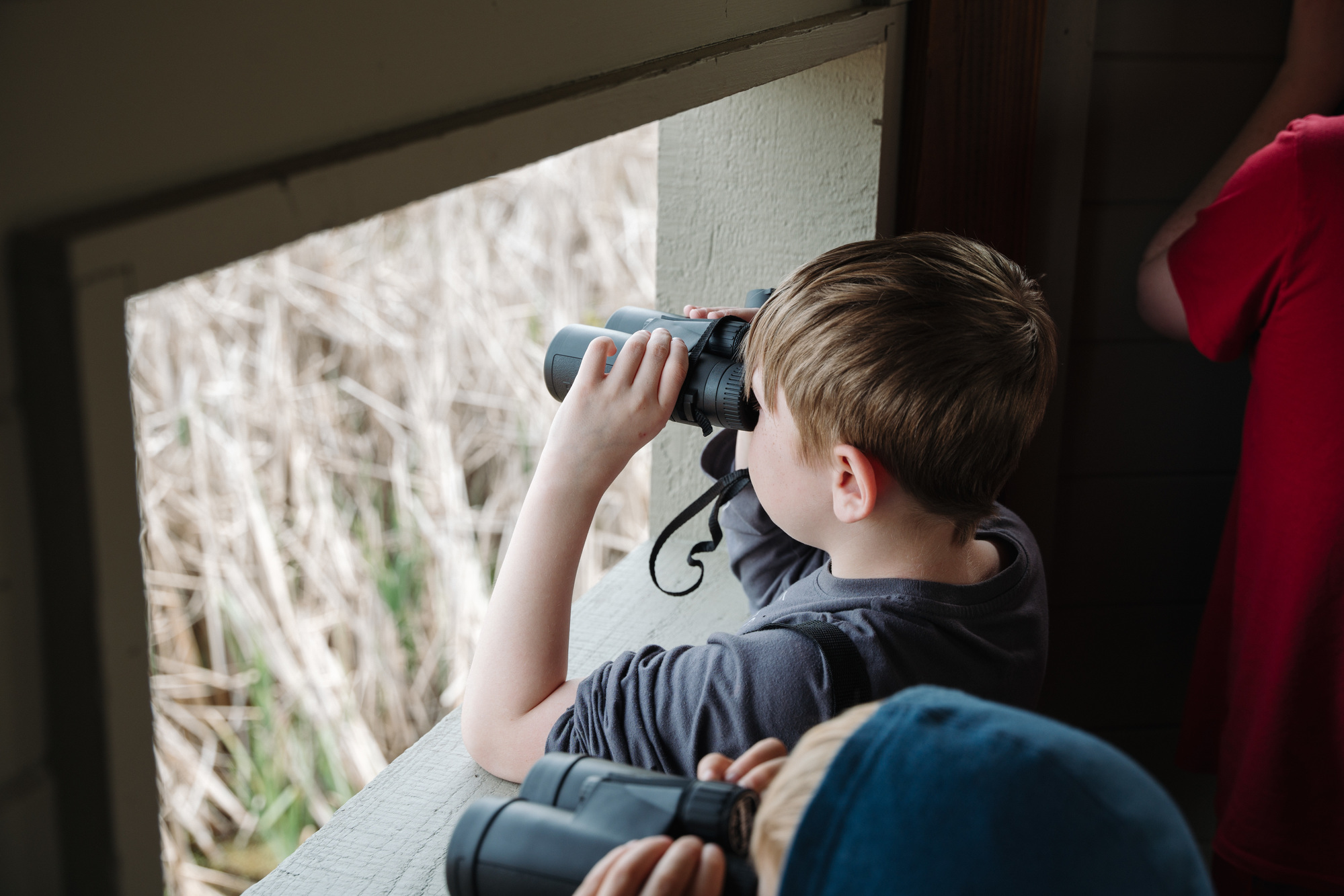 a boy looking through binoculars