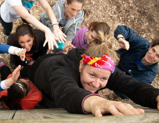 a group of people reaching for a woman