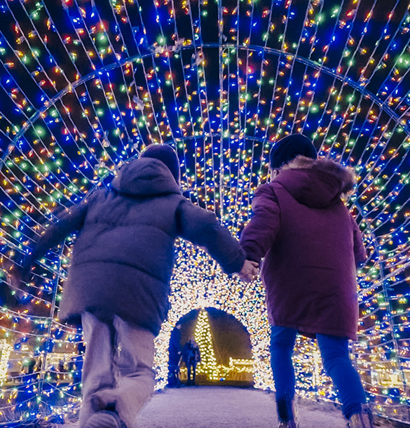 Children holding hands running through a light tunnel